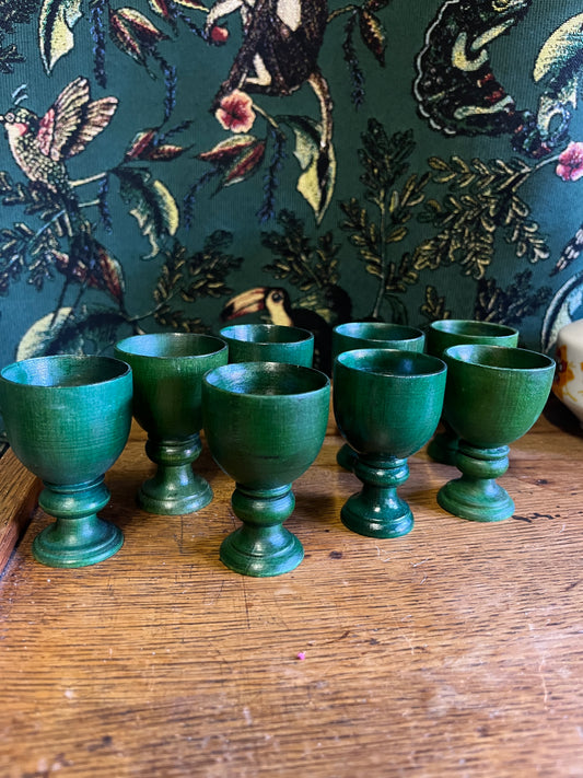 Set of eight green wooden egg cups