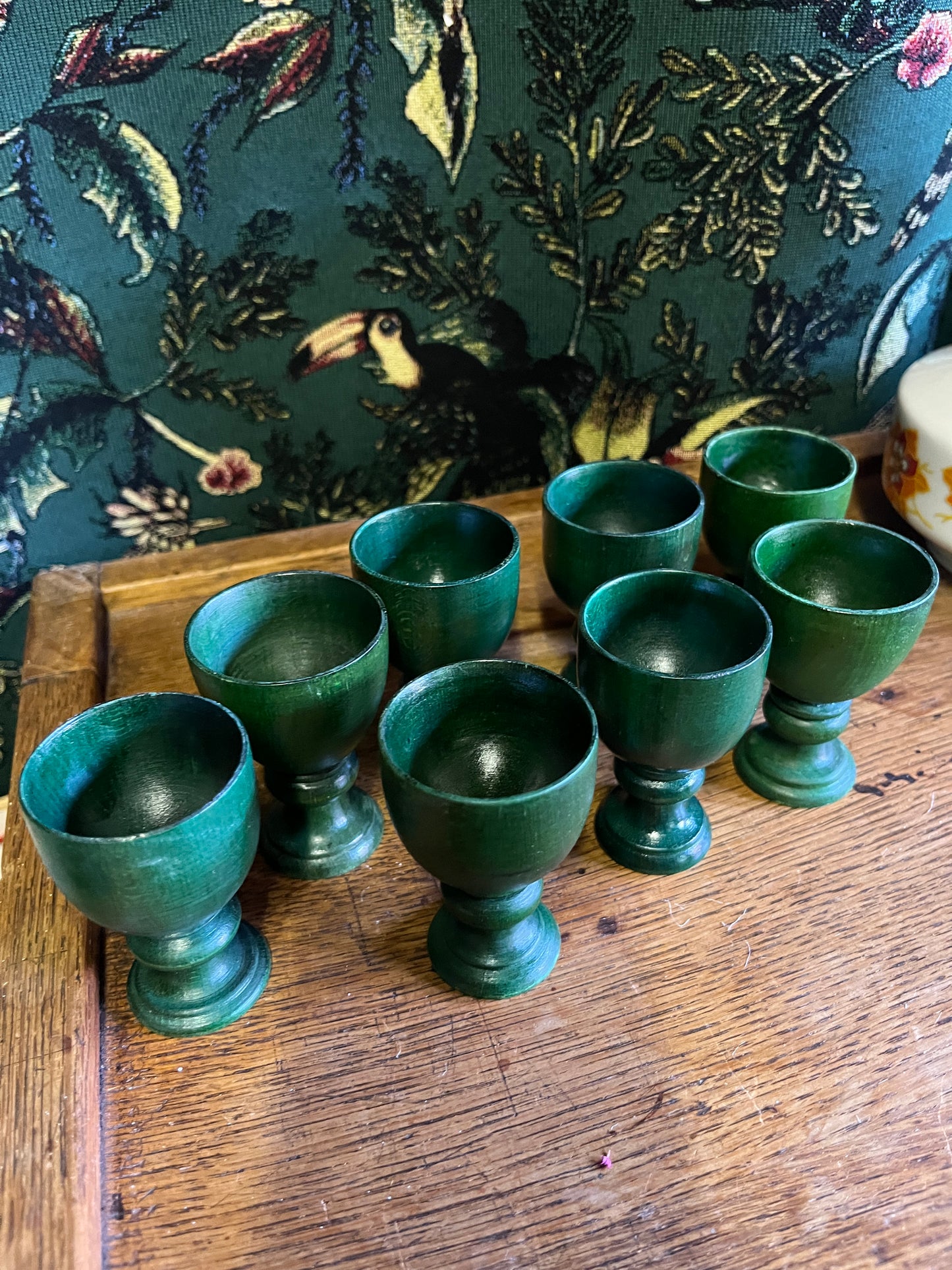 Set of eight green wooden egg cups