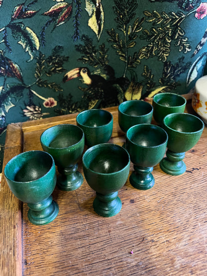 Set of eight green wooden egg cups