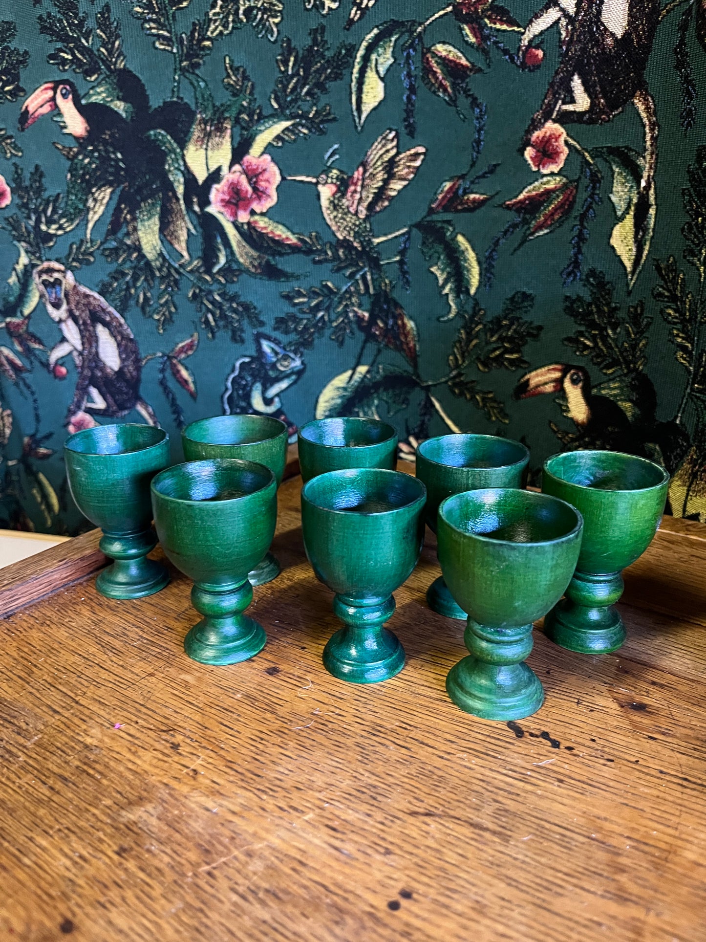 Set of eight green wooden egg cups